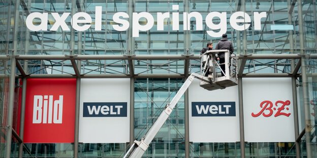 Der Schriftzug "Axel Springer" ist über den Logos von "Bild", "Welt" und "B.Z." zu sehen