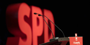 Vor einem großen SPD-Logo ist ein Pult mit einem Mikrofon zu sehen