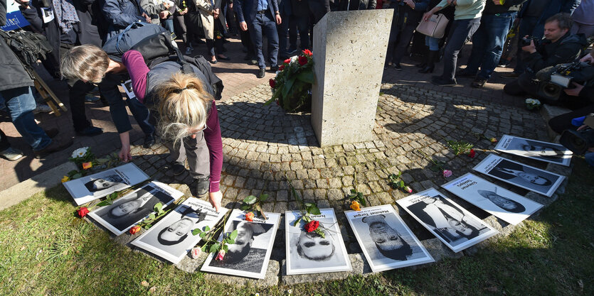 Menschen legen am Halitplatz Blumen nieder