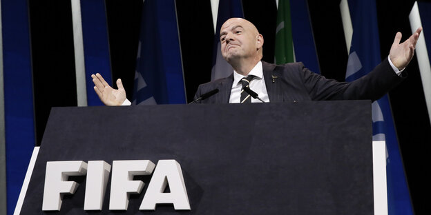 Gianni Infantino gestikuliert, darunter ist das Logo der FIFA zu sehen