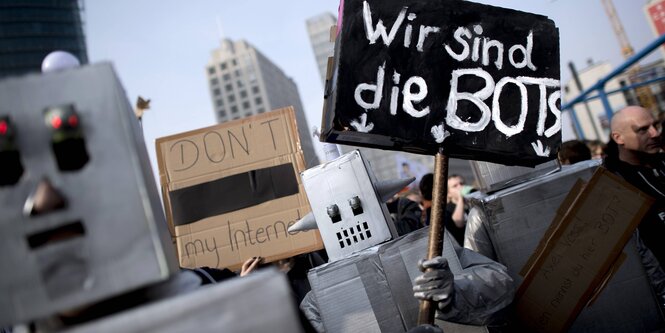 Roboterfiguren und ein Schild "Wir sind die Bots"