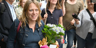 Vor der Bremer SPD-Zentrale steht Maike Schaefer mit einem Blumenstrauß