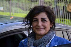Eine Frau mit langen Haaren steht vor einem Auto Eine Frau mit langen Haaren steht vor einem Auto