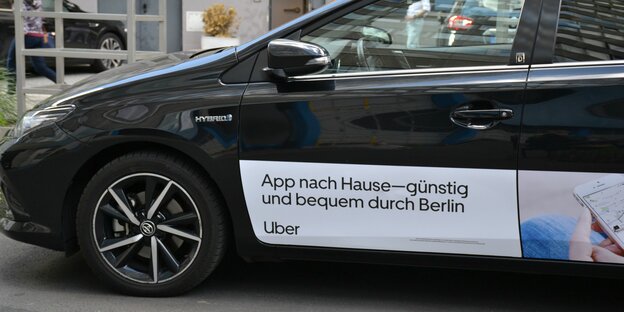 Ein elektroauto mit Werbeschriftzug steht in Berlin auf der Straße