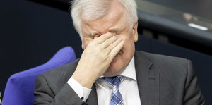 Horst Seehofer (CSU), Bundesinnenminister, reibt sich im Plenum im Bundestag die Augen