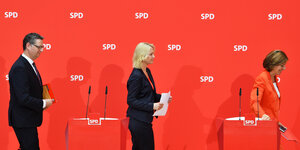 Die drei SPD-PolitikerInnen Thorsten Schäfer-Gümbel, Manuela Schwesig und Malu Dreyer stehen vor einer roten Wand und gehen weg