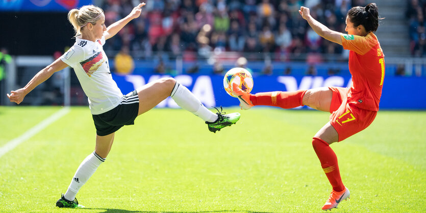 Zwei Fußballerinnen treten nach einem Ball