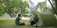 Zwei Protestierende sitzen an ihrem Zelt im We4Future-Camp