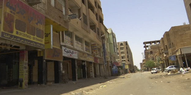 Eine menschenleere Straße im Sudan mit verlassenen Geschäften