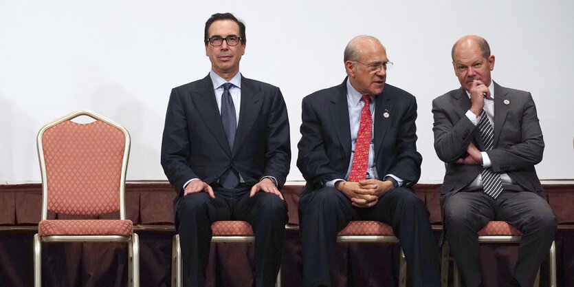 Steve Mnuchin, Jose Angel Gurria und Olaf Scholz sitzen nebeneinander