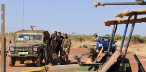 Ein Auto und Soldaten in einer wüstenähnlichen Landschaft