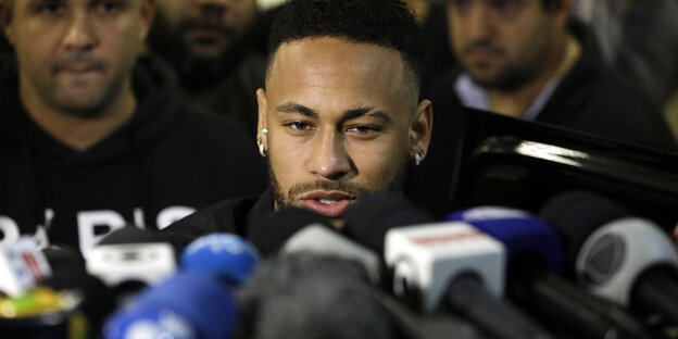 Der Fußballspieler Neymar steht vor Mikrofonen
