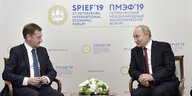 Kretschmer und Putin sitzen auf Stühlen und reden miteinder