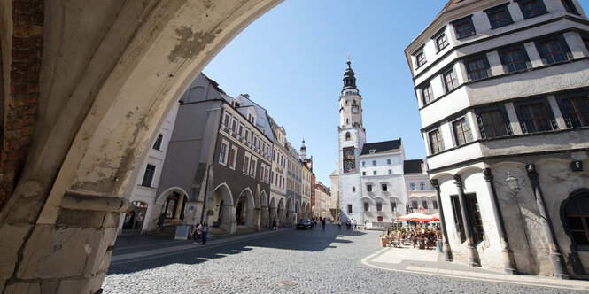 Das Foto zeigt die Sicht durch einen Torbogen in die Görlitzer Altstadt und den kopfsteingepflasterten Untermarkt