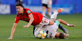 zwei am Boden liegende Fußballerinnen