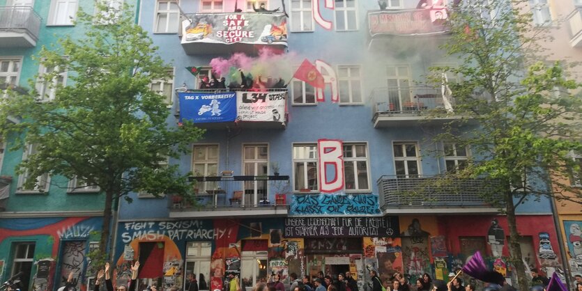 1. Mai-Demo vor der Rigaer Straße 94. Menschen mit Bengalos auf den balkonen