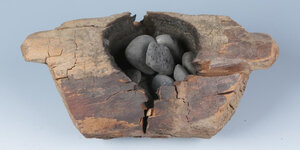 Ein hölzernes Rauchgefäß mit verbrannten Steinen