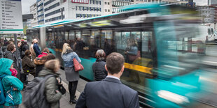 Bus inmitten einer Fahrgastmenge