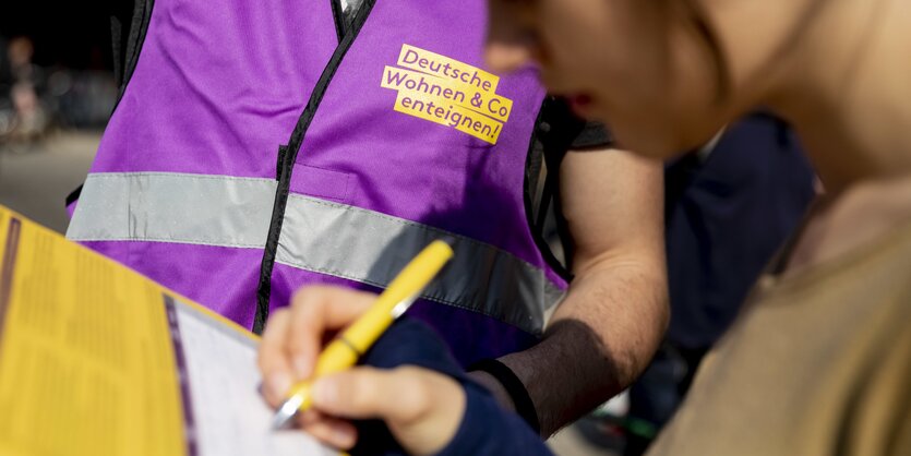 Eine Frau unterschreibt bei der Demonstration gegen steigende Mieten vom Bündnis gegen Verdrängung