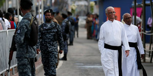 Soldaten und Priester laufen auf einer Straße