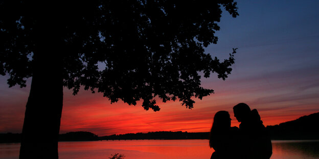 Die Silhouetten eines Paars vor Sonnenuntergang