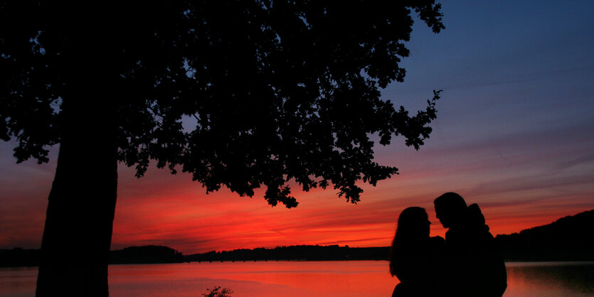 Die Silhouetten eines Paars vor Sonnenuntergang