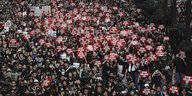 Tausende Demonstrierende in schwarzer Kleidung ziehen durch Hongkong. Viele halten Schilder auf der Hand, auf denen "stop killing us" (höre auf, uns zu töten) in der Hand