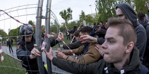 Polizisten und Demonstranten drängen sich an einem Zaun