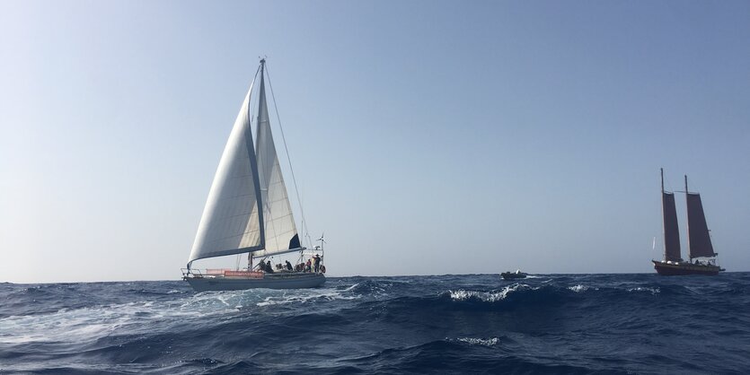 Zwei Yachtschiffe auf dem Meer. Der Himmel ist blau.