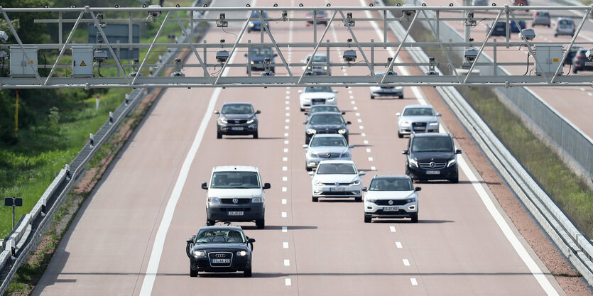 Verschiedene Pkw und Transporter fahren unter einer Mautbrücke auf der Autobahn A9 hindurch