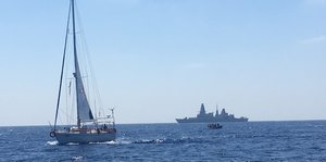 Ein Segelboot, ein Schnellboot und ein Kriegsschiff auf offenem Meer