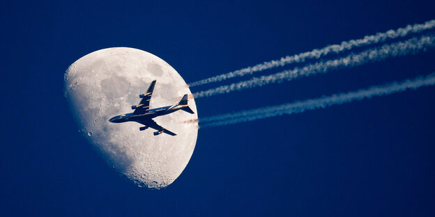 Ein Flugzeug fliegt scheinbar ganz nah am Mond vorbei