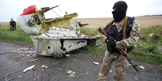 Ein pro-russischer Kämpfervor einem Wrackteil der MH 17 im Juli 2014 in der Ostukraine