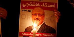 Ein Plakat mit einem Bild von Khashoggi, davor eine Kerze.