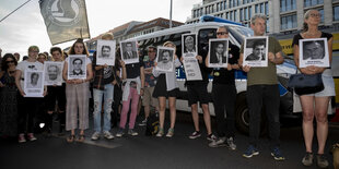 Menschen halten Fotos von Ermordeten durch rechte Gewalt hoch