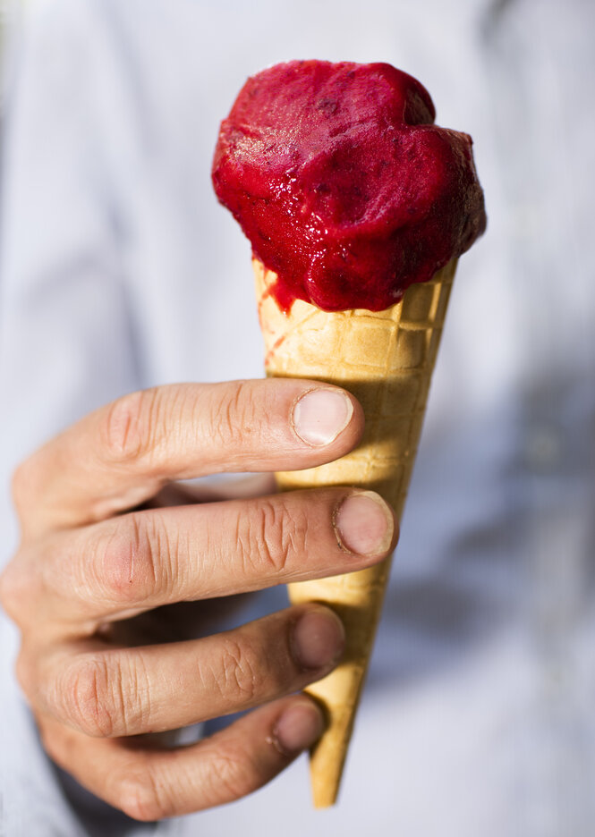 Johannes von Weizsäcker hält eine Kugel Eis in der Hand - Erdbeereis