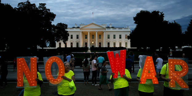 Demonstranten vor dem Weißen Haus halten Tafeln mit den Buchstaben NO WAR hoch