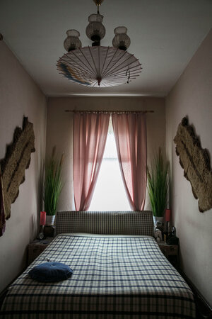 Ein Schlafzimmer mit Bett, rosa Vorhängen und Kronleuchter