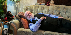 Ein älterer Mann liegt auf einem Sofa
