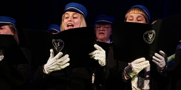 Frauen in Unifom singen im Chor
