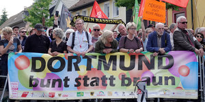 Demonstranten protestieren mit einem Transparent mit der Aufschrift "Dortmund bunt statt braun".