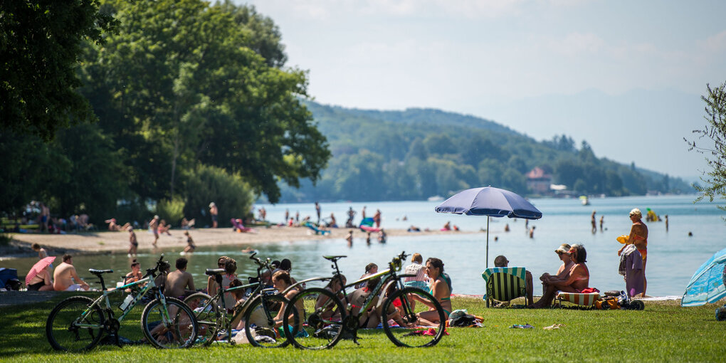 An einem Badestrand liegen viele Menschen in der Sonne