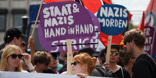 Menschen auf einer Demo. Viele Protest-Schilder.