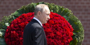 ein Mann vor einem riesigen Strauß roter Blumen