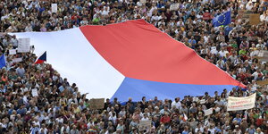 Demonstranten tragen eine riesige tschechische Fahne