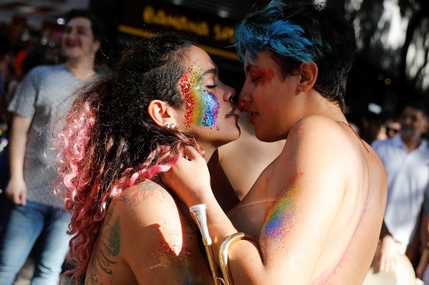 Zwei Frauen mit bemalten Gesichtern küssen sich