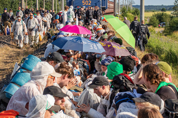 Aktivisten sitzen auf den Gleisen und blockieren die Kohle-Transportbahn