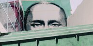 Putins Conterfei an einer Hauswand, die untere Hälfte ist von einem Mülleimer verdeckt