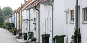 Mülltonnen stehen vor einer Reihe Häuser in einer Neubausiedlung in Regensburg