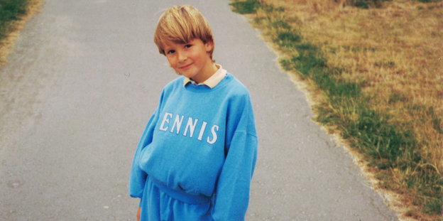 Junge im blauen Trainingsanzug auf einer Straße